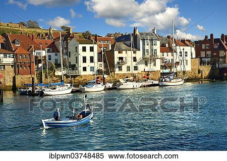 Stock Photography - "Fisherman in boat in Whitby Harbour, Whitby, North Yorkshire, England, United Kingdom, Europe". Fotosearch