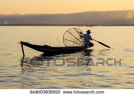 "Fisherman in the evening light, with a traditional basket, sitting on the canoe, sunset at Inle Lake, Shan State, Myanmar, Asia" View Large Photo Image Stock Image - "Fisherman in the evening light, with a traditional basket, sitting on the canoe, sunset at Inle Lake, Shan State, Myanmar, Asia". Fotosearch
