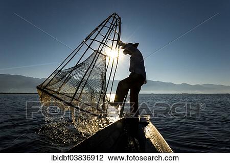 "Fisherman in the morning light, with a traditional basket on the canoe, at sunrise, Inle Lake, Shan State, Myanmar, Asia" View Large Photo Image Stock Image - "Fisherman in the morning light, with a traditional basket on the canoe, at sunrise, Inle Lake, Shan State, Myanmar, Asia". Fotosearch
