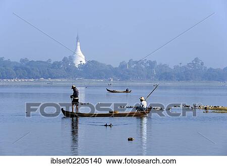 Stock Image - "Fishermen in a fishing boat, a pagoda at the back, Burma, Myanmar, Southeast Asia, Asia". Fotosearch