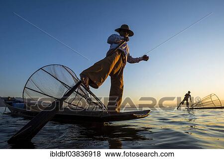 "Fishermen in the evening light, leg rowers with a traditional basket on their canoes, sunset at Inle Lake, Shan State, Myanmar, Asia" View Large Photo Image Stock Photo - "Fishermen in the evening light, leg rowers with a traditional basket on their canoes, sunset at Inle Lake, Shan State, Myanmar, Asia". Fotosearch