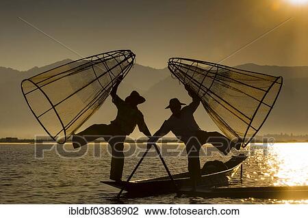 "Fishermen in the morning light, with traditional baskets in their canoes, at sunrise, Inle Lake, Shan State, Myanmar, Asia" View Large Photo Image Stock Image - "Fishermen in the morning light, with traditional baskets in their canoes, at sunrise, Inle Lake, Shan State, Myanmar, Asia". Fotosearch