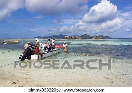 Stock Photo - "Fishermen loading their freshly caught fish on the beach, Praslin, Seychelles, Africa". Fotosearch