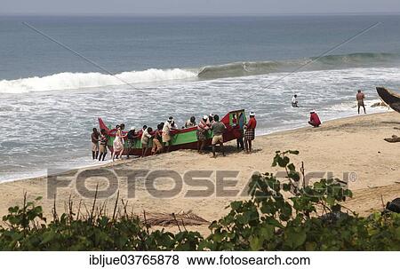 Stock Photo - "Fishermen pushing their boat out of the water onto the beach, Varkala, Kerala, India, Asia". Fotosearch