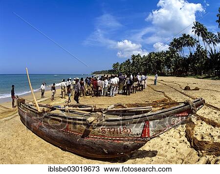 Stock Image - "Fishing boat and fishermen on the beach, Beruwala, Kalutara Distrikt, Sri Lanka, Asia". Fotosearch