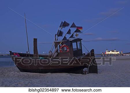 Stock Photo - "Fishing boat on a beach in the evening, pier, Ahlbeck, Usedom Island, Mecklenburg-Western Pomerania, Germany, Europe". Fotosearch