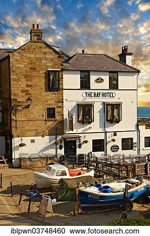 Stock Image - "Fishing boats and the Bay Hotel, historic fishing village of Robin Hood's Bay, North Yorkshire, England, United Kingdom, Europe". Fotosearch