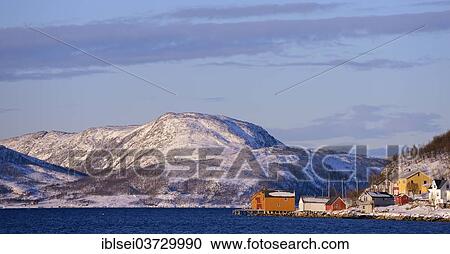 Stock Image - "Fishing village beside a fjord with wintry mountains, Sommeroya, Tromso, â€ªTroms, Northern Norway, Norway, Europe". Fotosearch