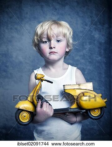 "Five-year-old boy holding a toy Vespa scooter, gift, sad face" View Large Photo Image Picture - "Five-year-old boy holding a toy Vespa scooter, gift, sad face". Fotosearch