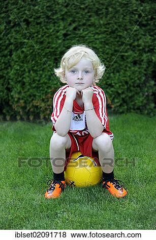 "Five-year-old boy wearing a FC Bayern Munich soccer dress, sitting on a yellow soccer ball" View Large Photo Image Stock Photo - "Five-year-old boy wearing a FC Bayern Munich soccer dress, sitting on a yellow soccer ball". Fotosearch
