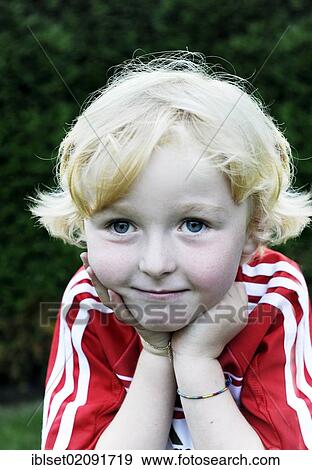 Stock Photo - "Five-year-old boy wearing a FC Bayern Munich soccer dress, head resting on his hands, portrait". Fotosearch