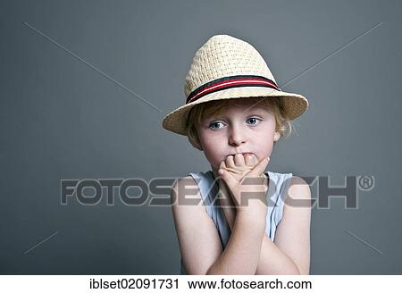 Stock Image - "Five-year-old boy wearing a hat, sad face, portrait". Fotosearch