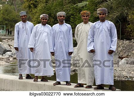 "Five young Omani men wearings traditional dishdasha festive clothes during a trip to the hot springs of Ain A'Thawwarah, Nakhl, Oman, Asia" View Large Photo Image Stock Image - "Five young Omani men wearings traditional dishdasha festive clothes during a trip to the hot springs of Ain A'Thawwarah, Nakhl, Oman, Asia". Fotosearch