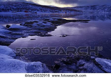 Stock Photograph - "Fjord with an ice-covered shore in the evening light, Tromso, â€ªTroms, Northern Norway, Norway, Europe". Fotosearch