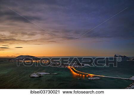 Stock Image - "Fjord with an illuminated bridge in winter at sunset, Sommeroya, Tromso, â€ªTroms, Northern Norway, Norway, Europe". Fotosearch