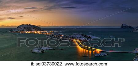 Stock Image - "Fjord with an illuminated bridge in winter at sunset, Sommeroya, Tromso, â€ªTroms, Northern Norway, Norway, Europe". Fotosearch