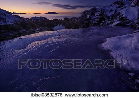 Stock Photograph - "Fjord with ice and rocks at sunset, Tromso, â€ªTroms, Northern Norway, Norway, Europe". Fotosearch