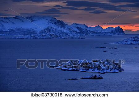 Stock Photo - "Fjord with mountains in winter at sunset, Sommeroya, Tromso, â€ªTroms, Northern Norway, Norway, Europe". Fotosearch