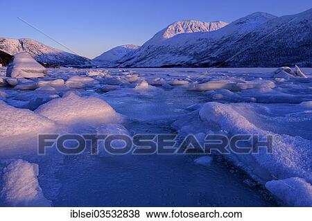 "Fjord with snow-covered stones and ice floes in front of a mountain range, Tromso, ‪Troms, Northern Norway, Norway, Europe" View Large Photo Image Stock Photo - "Fjord with snow-covered stones and ice floes in front of a mountain range, Tromso, ‪Troms, Northern Norway, Norway, Europe". Fotosearch
