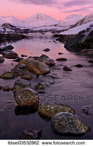 "Fjord with stones in front of a mountain range in the evening light, Tromso, ‪Troms, Northern Norway, Norway, Europe" View Large Photo Image Stock Image - "Fjord with stones in front of a mountain range in the evening light, Tromso, ‪Troms, Northern Norway, Norway, Europe". Fotosearch