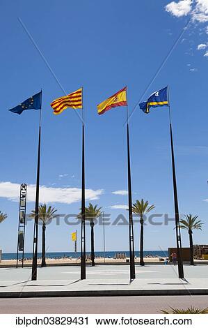Stock Image - "Flags of Spanish regions on flagpoles against blue sky, Salou, Catalonia, Europe". Fotosearch