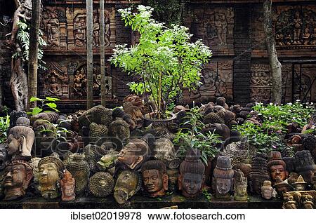"Flowers and plants growing between historic Buddha heads made of stone, Cambodia, Asia" View Large Photo Image Stock Photo - "Flowers and plants growing between historic Buddha heads made of stone, Cambodia, Asia". Fotosearch