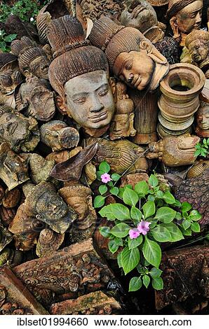 "Flowers growing between old, weathered Buddha heads, Cambodia, Southeast Asia, Asia" View Large Photo Image Stock Image - "Flowers growing between old, weathered Buddha heads, Cambodia, Southeast Asia, Asia". Fotosearch