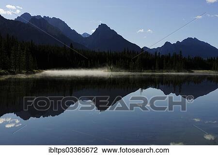 Stock Image - "Foothills of the Rocky Mountains reflected in a lake, Kananaski Country, Alberta, Canada, Kananaskis Country, Canmore, Alberta Province, Canada, North America". Fotosearch