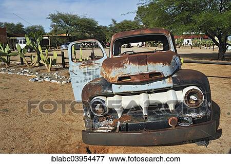 Stock Photo - "Ford car wreck with energy saving bulbs, Solitaire, historically Areb, since 1848 a small private settlement on the same named farm, Namib-Naukluft National Park, Namibia, Africa". Fotosearch