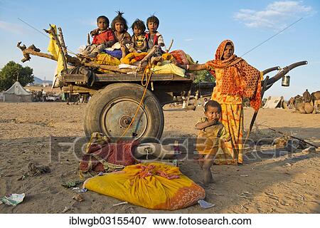 "Four children sitting on a camel cart, woman and a little boy standing next to it, Pushkar Camel Fair, Pushkar, Rajasthan, India, Asia" View Large Photo Image Stock Photo - "Four children sitting on a camel cart, woman and a little boy standing next to it, Pushkar Camel Fair, Pushkar, Rajasthan, India, Asia". Fotosearch