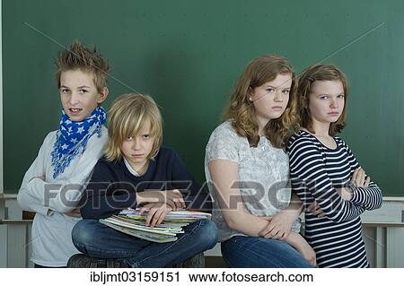 "Four grumpy school children in a classroom, Germany, Europe" View Large Photo Image Stock Image - "Four grumpy school children in a classroom, Germany, Europe". Fotosearch