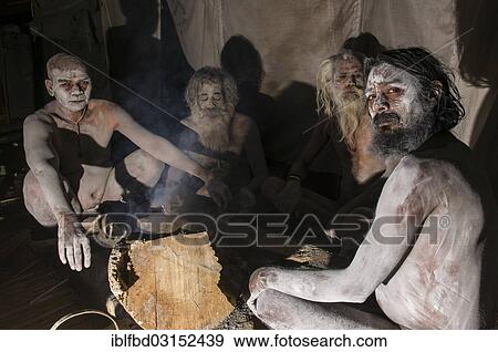 "Four newly initiated Shiva sadhus from Avahan Akhara, holy men, sitting around a bonfire, during Kumbha Mela festival, Allahabad, Uttar Pradesh, India, Asia" View Large Photo Image Stock Photo - "Four newly initiated Shiva sadhus from Avahan Akhara, holy men, sitting around a bonfire, during Kumbha Mela festival, Allahabad, Uttar Pradesh, India, Asia". Fotosearch