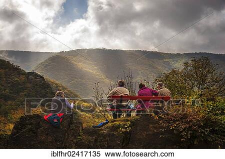 Stock Photography - Four People having a break on a bench on the Rotweinwanderweg trail, Altenahr, Rhineland-Palatinate, Germany, Europe. Fotosearch