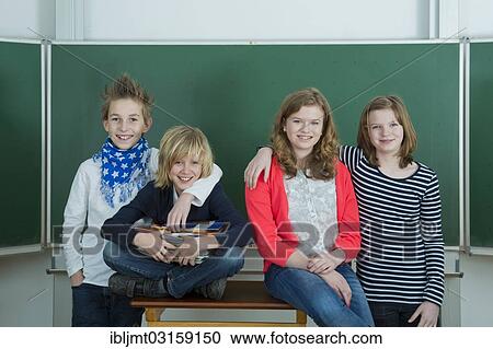 "Four smiling schoolchilden in the classroom, Germany, Europe" View Large Photo Image Stock Image - "Four smiling schoolchilden in the classroom, Germany, Europe". Fotosearch