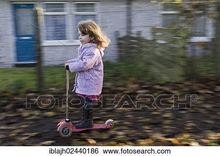 Four-year-old girl having fun riding a scooter View Large Photo Image Stock Photograph - Four-year-old girl having fun riding a scooter. Fotosearch