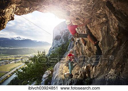 Stock Image - "Freeclimber with helmet climbing on a rock face, Martinswand, gallery, Innsbruck, Tyrol, Austria, Europe". Fotosearch