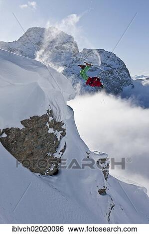Stock Photograph - "Freerider, skier jumping over a rock, snowy landscape, Engadin valley, Switzerland, Europe". Fotosearch