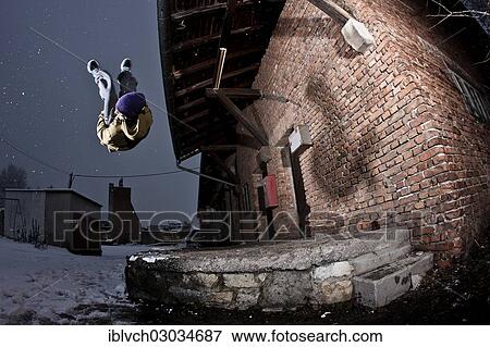 Stock Photo - "Freerunner doing a somersault at an old industrial site, Schwaz, Tyrol, Austria, Europe". Fotosearch
