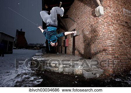 "Freerunner doing a somersault at an old industrial site, Schwaz, Tyrol, Austria, Europe" View Large Photo Image Stock Photograph - "Freerunner doing a somersault at an old industrial site, Schwaz, Tyrol, Austria, Europe". Fotosearch