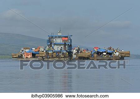 Stock Photograph - "Freighter transporting logs of tropical timber on the Congo River, near Kinshasa, Kinshasa District, Democratic Republic of the Congo". Fotosearch