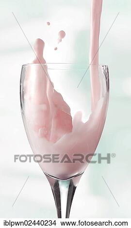 Picture - Fresh flavoured milk being poured into a glass. Fotosearch