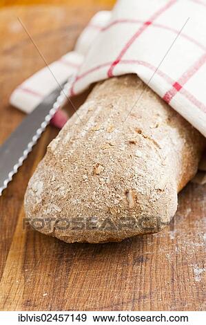 Fresh loaf of bread and kitchen knife on a wooden cutting board View Large Photo Image Stock Photo - Fresh loaf of bread and kitchen knife on a wooden cutting board. Fotosearch
