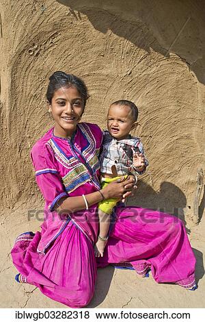 "Friendly smiling girl in traditional dress holding a small boy in her arms, Rann of Kutch, Gujarat, India, Asia" View Large Photo Image Stock Photo - "Friendly smiling girl in traditional dress holding a small boy in her arms, Rann of Kutch, Gujarat, India, Asia". Fotosearch