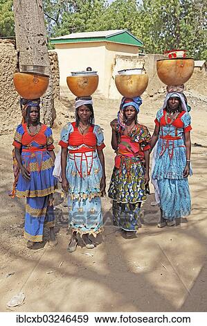 Stock Photo - "Fulani women carrying milk calabashes on their heads, Maga Dam, Pouss, Far North, Cameroon, Africa". Fotosearch