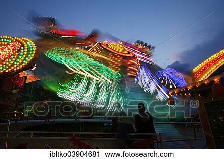 Stock Image - "Funfair ride, funfair in the evening, Cologne, Rhineland, North Rhine-Westphalia, Germany, Europe". Fotosearch