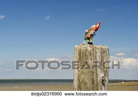 Stock Image - "Garden gnome on the top of the jetty, Utersum, Foehr island, North Frisia, Schleswig-Holstein, Germany, Europe". Fotosearch