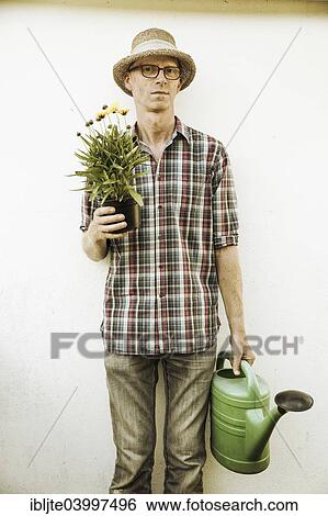 "Gardener, garden plot holder, holding a flower and a watering can, Germany, Europe" View Large Photo Image Stock Photograph - "Gardener, garden plot holder, holding a flower and a watering can, Germany, Europe". Fotosearch