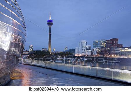 Stock Photo - "Gehry buildings at dusk, Neuer Zollhof building complex and the Rheinturm tower, Medienhafen district, Duesseldorf, North Rhine-Westphalia, Germany, Europe". Fotosearch