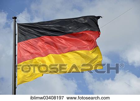 Stock Photo - "German flag against a blue sky with clouds, Berlin, Berlin, Germany, Europe". Fotosearch