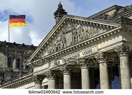 Stock Image - "German flag flying on the Reichstag building, parliament, Bundestag, lettering on the tympanum above the main portal """"Dem Deutschen Volke"""", German for """"to the German people"""", Government District, Berlin, Berlin, Germany, Europe". Fotosearch